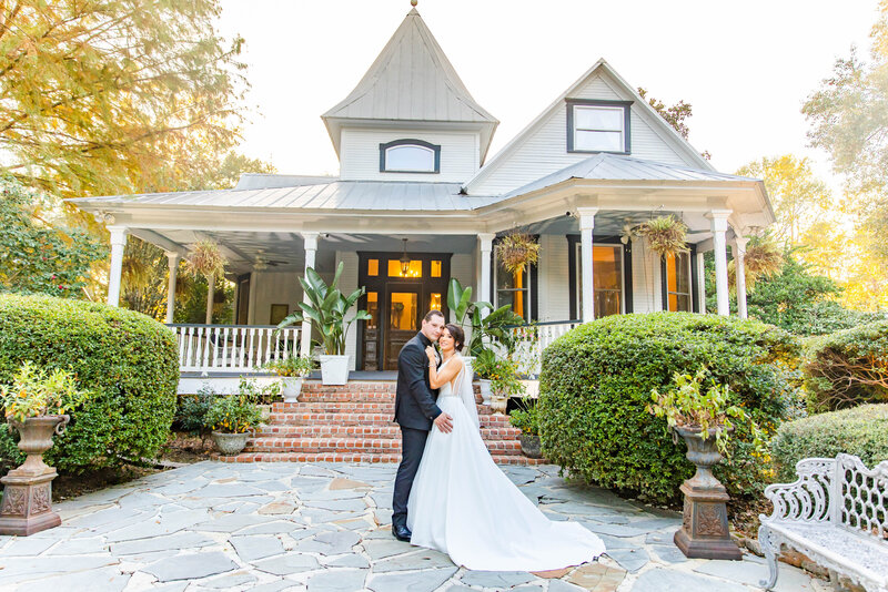 Sophisticated bride and groom embrace outside the Henry Smith House on their wedding day