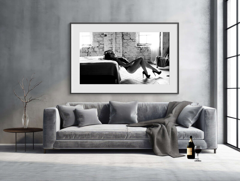 Grey couch with a wine bottle and a framed Hamilton Boudoir photo