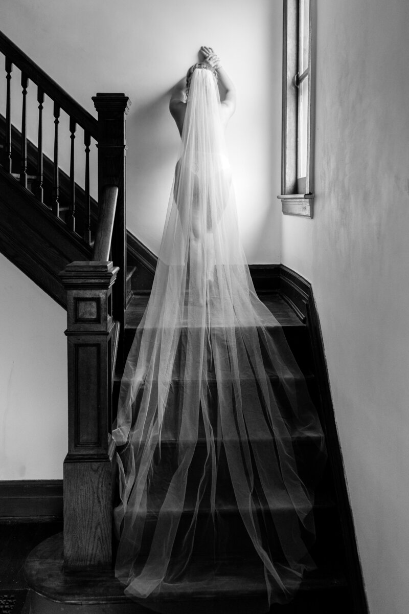 bride walking up staircase with veil