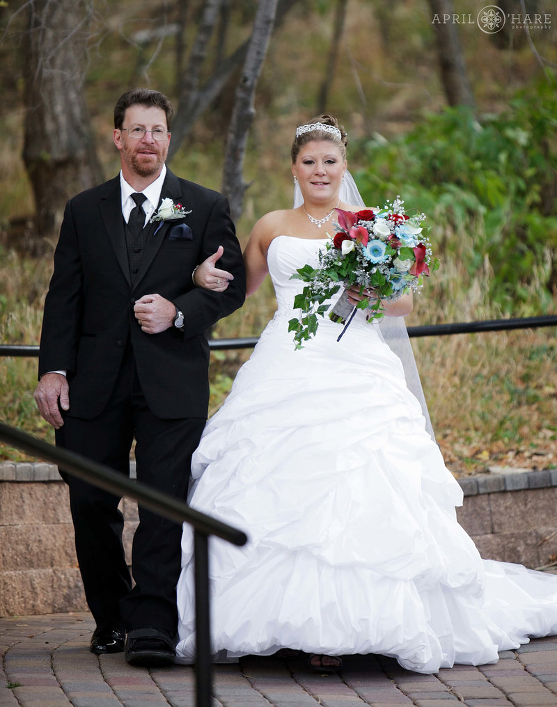 Father walks with his daughter down aisle to Aspen Terrace at Pines at Genesee