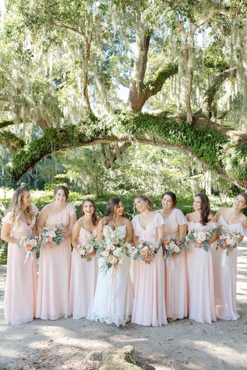 bride and bridesmaids photo standing on front of oak tree
