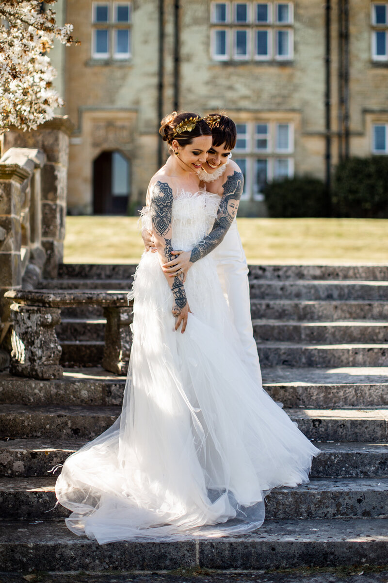 two brides laughing and posing in front blacombe place manor