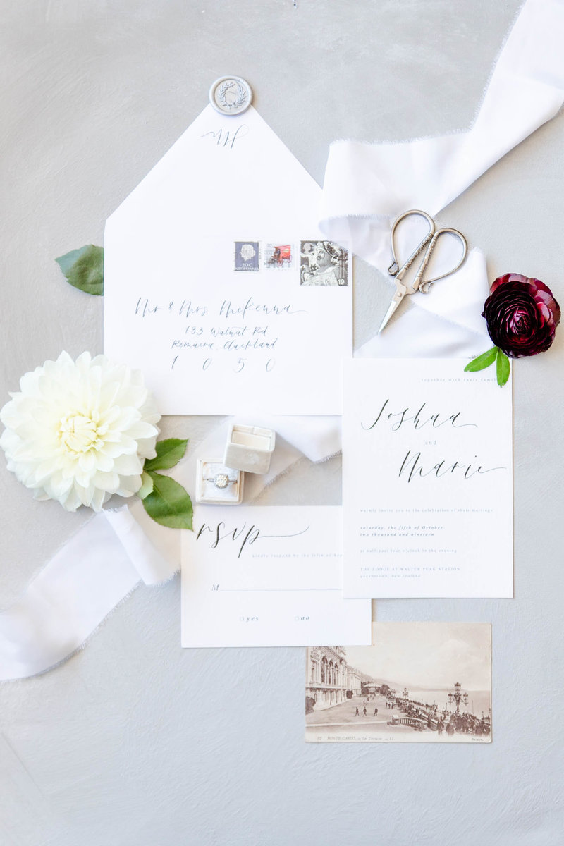 An arrangement of invitations with ribbon flowing between