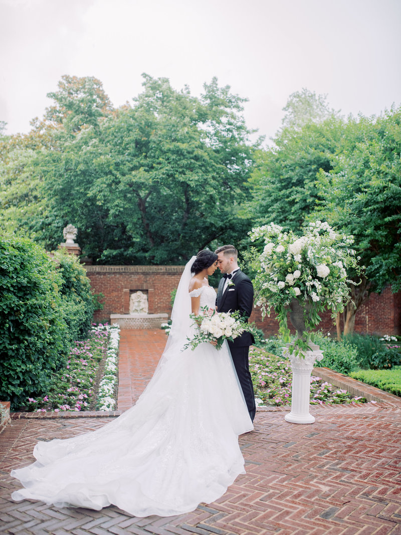 Bride and groom  with white  garden style flowers in Maryland