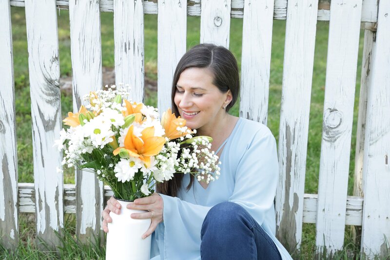Happy business owner smelling flowers