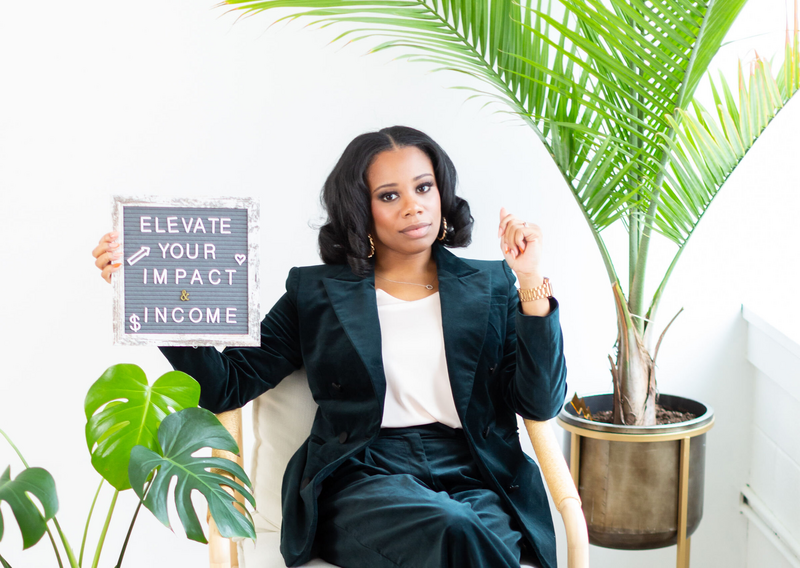woman holding up a sign that says elevate your impact and income