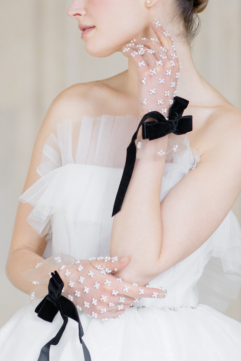 Bridal details of luxurious bridal gloves at Chateau de Champlatreux Wedding venue in Paris, France. Photographed by destination wedding photographer, Brittany Navin Photography