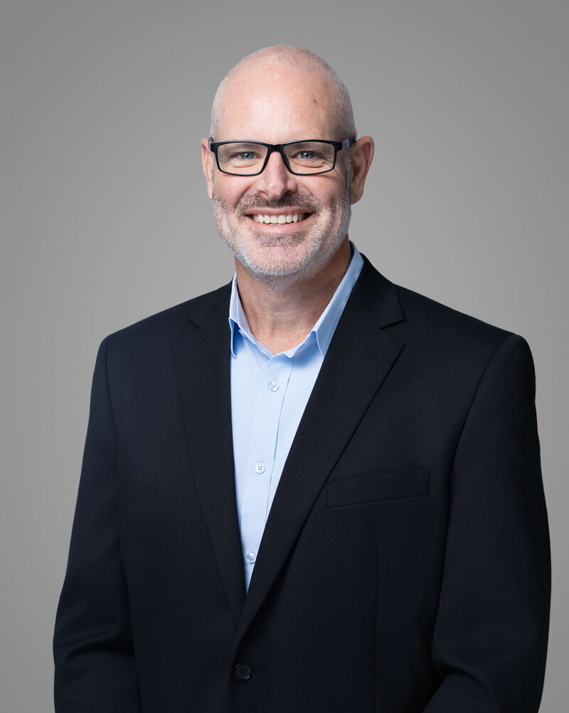 Professional headshot of Jon captured by Liza Hondros Photography in Fayetteville, North Carolina, showcasing a confident and approachable corporate portrait style.