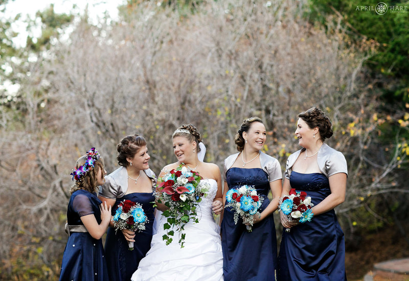 Bridesmaids wearing satin navy blue dresses at a fall wedding at The Pines at Genesee in Colorado
