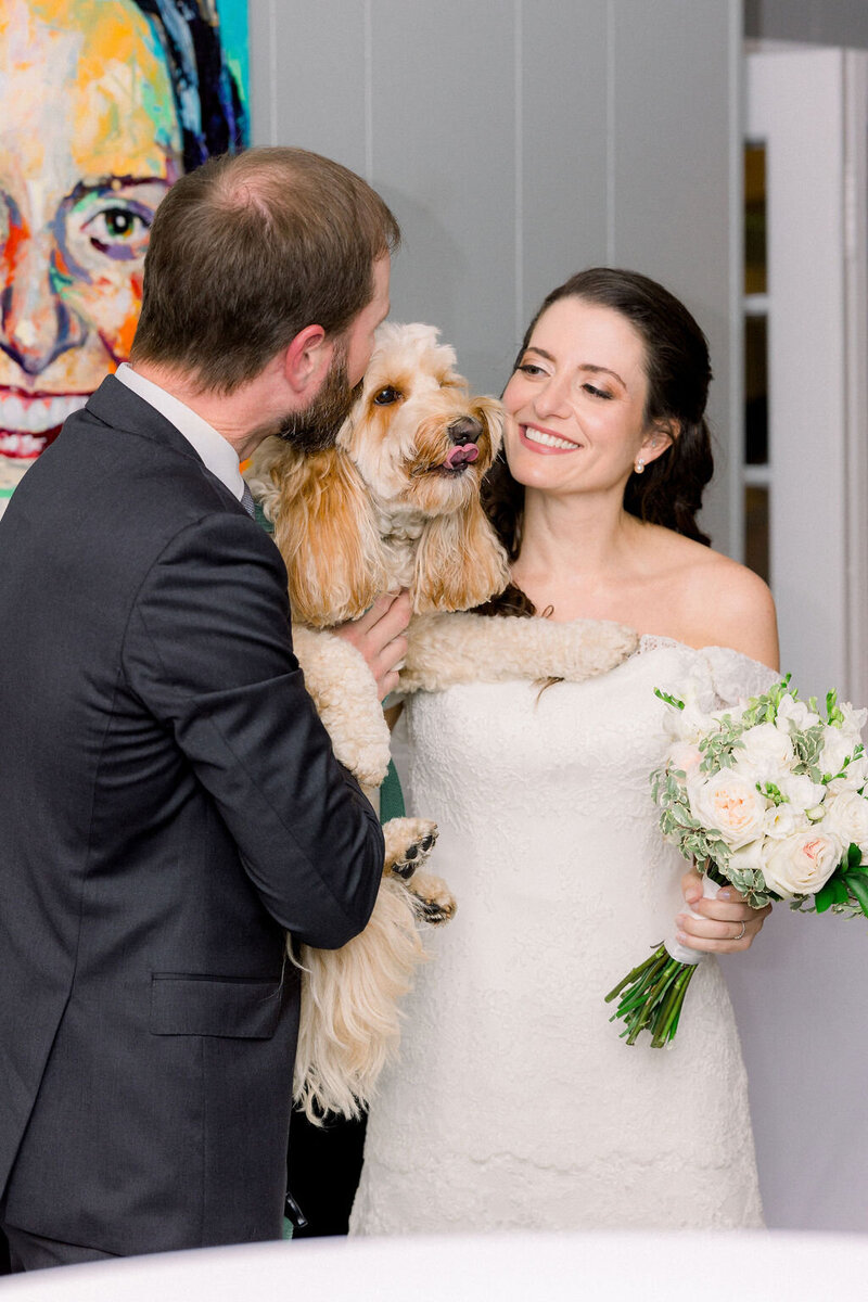 A lovely couple is happily married sharing a unique moment with their dog in the reception