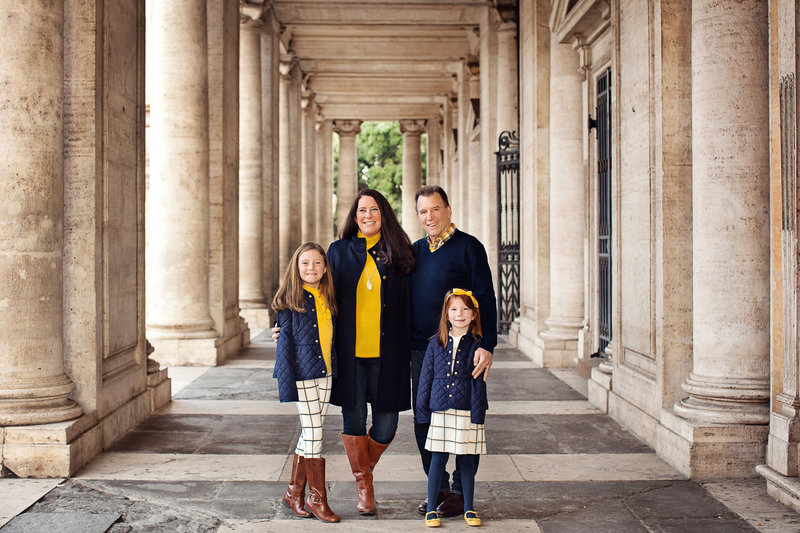 Family of four standing in the columns of the Roman Forum. Taken by Rome Family Photographer, Tricia Anne Photography