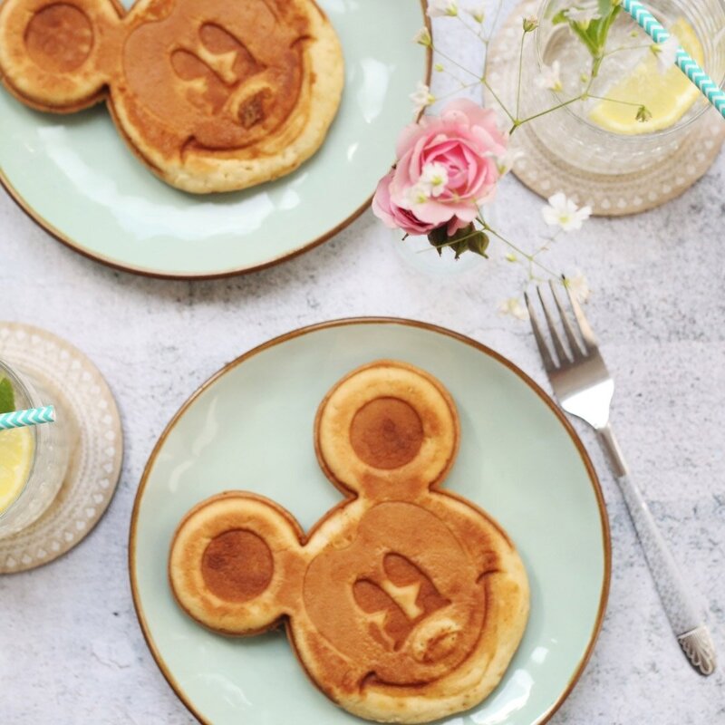 Mickey Mouse pancakes and pink rose on table