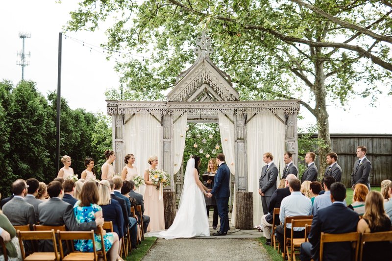 A large wedding party at a beautiful wedding ceremony officiated by Lehigh Valley Celebrants at the beautiful Terrain wedding venue in the Main Line Philadelphia area.