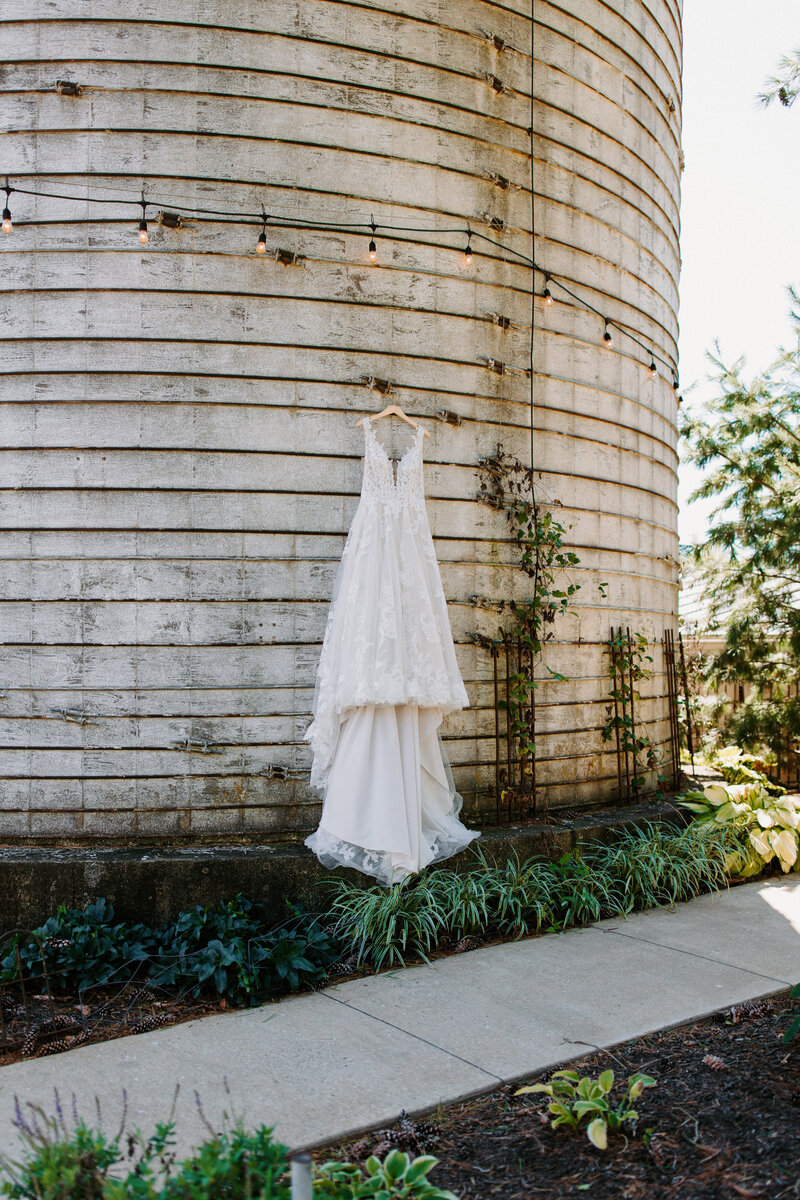wedding dress handing from the side of a rustic building outside