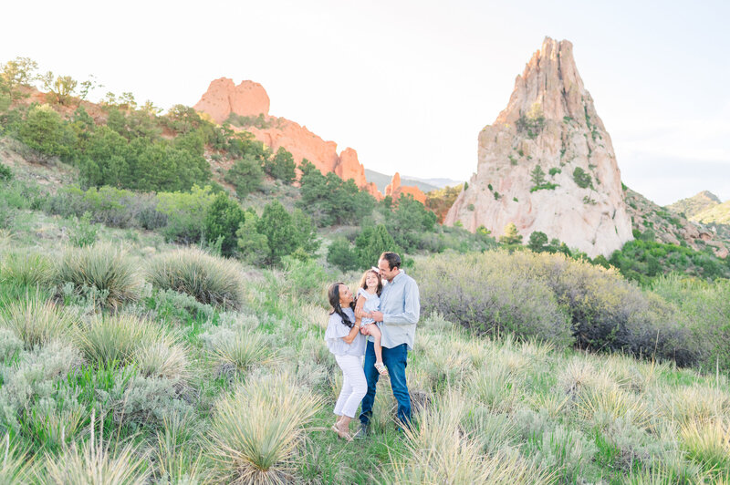 A family of three standing in a yucca field in Garden of the Gods park in Colorado Springs for their family photos.