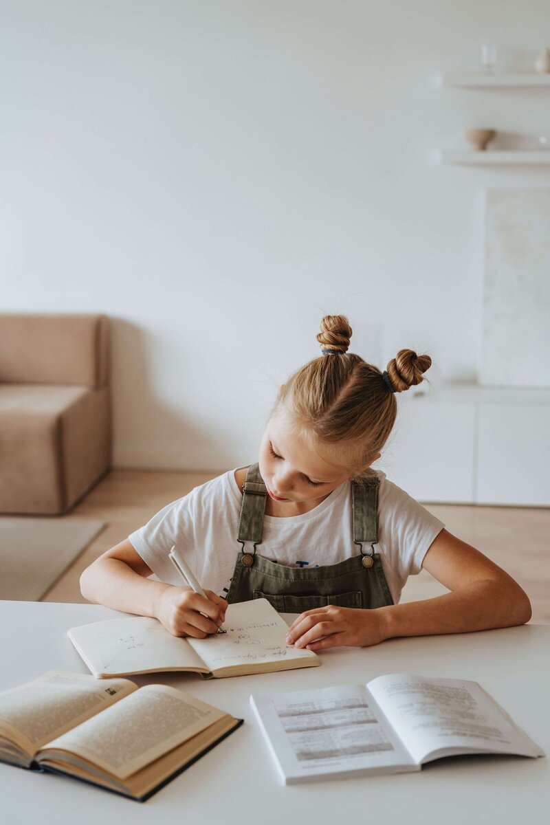 a young female student working at their desk on reading and writing