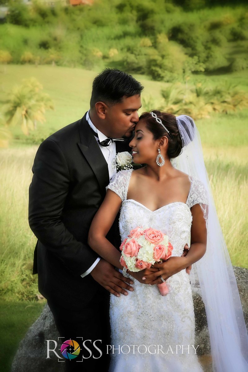 Groom kisses bride's forehead.. Photo by Ross Photography, Trinidad, W.I..