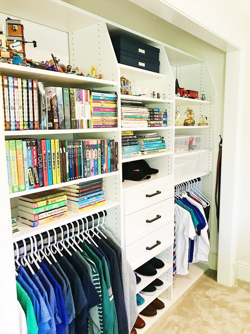 Custom closet with hanging clothes,  shelves for hats, shoes, books and toys.