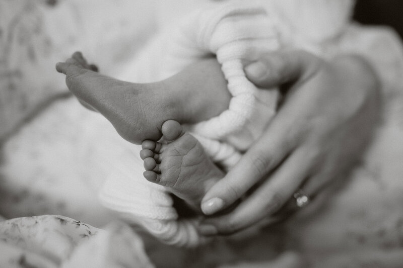mom holding infants tiny wrinkly feet