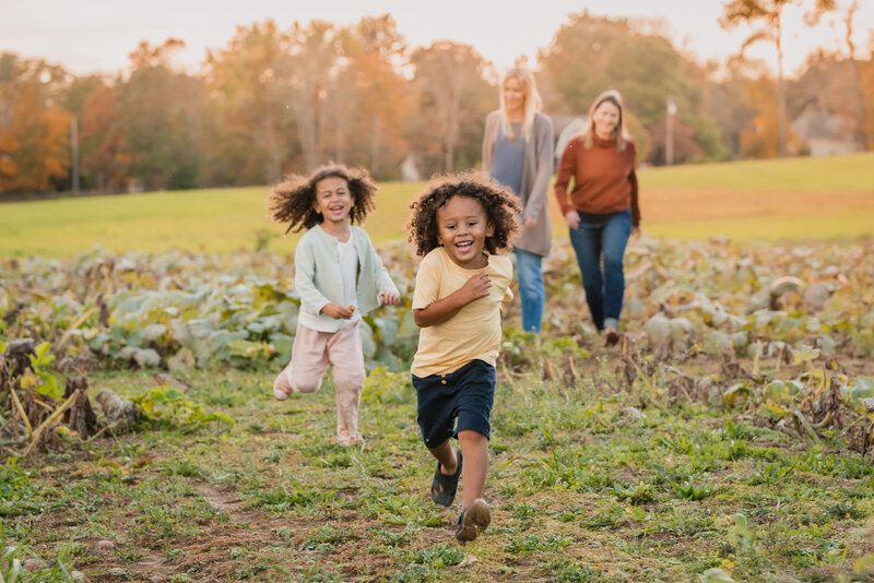 Boston Family Photo of kids running through pumpkin patch with moms
