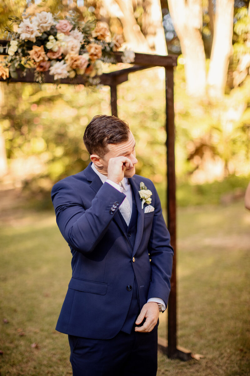 Groom cries as bride walks down the aisle at wedding ceremony