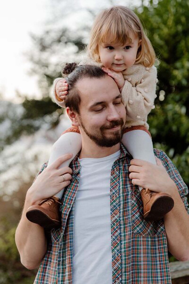 A dad carrying his tired child, a tender image of care and the protective, supportive role of parents in their children’s lives.