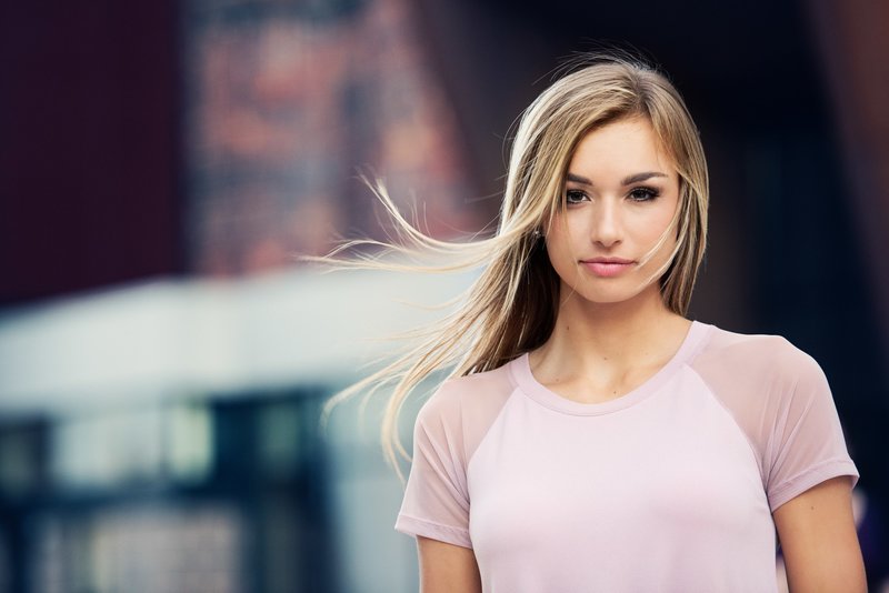 senior girl in pink shirt against colorful urban wall