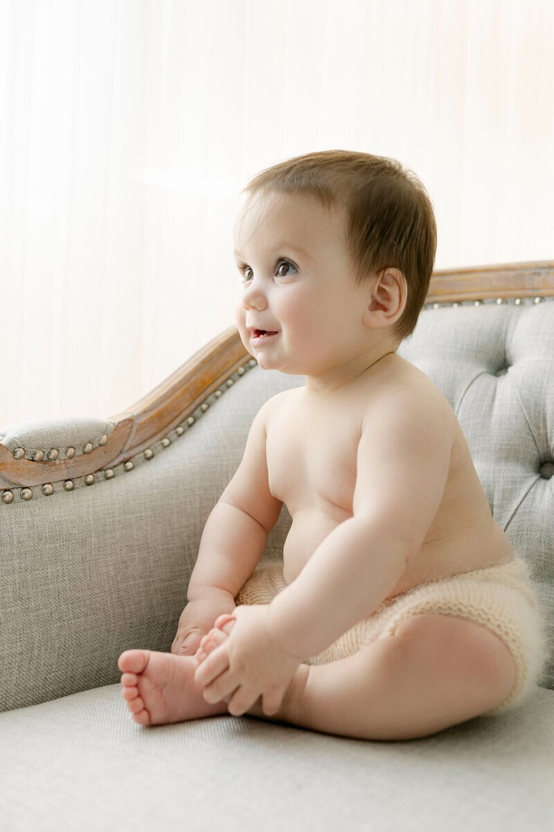 Baby sitting on bench smiling taken by cake smash photographer nj
