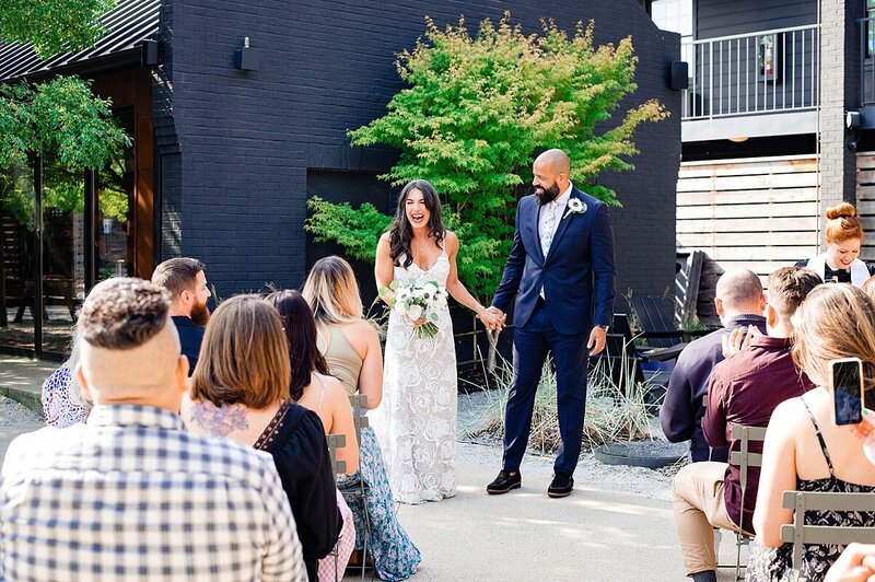 Bride and groom laughing together during their ceremony for their micro wedding in Nashville hotel courtyard