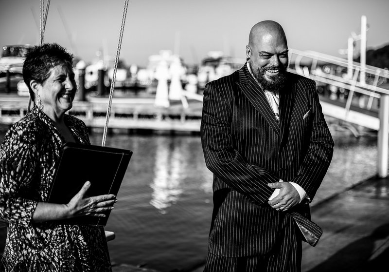 Groom and officiant smiling as they see the bride at an Erie Yacht Club wedding