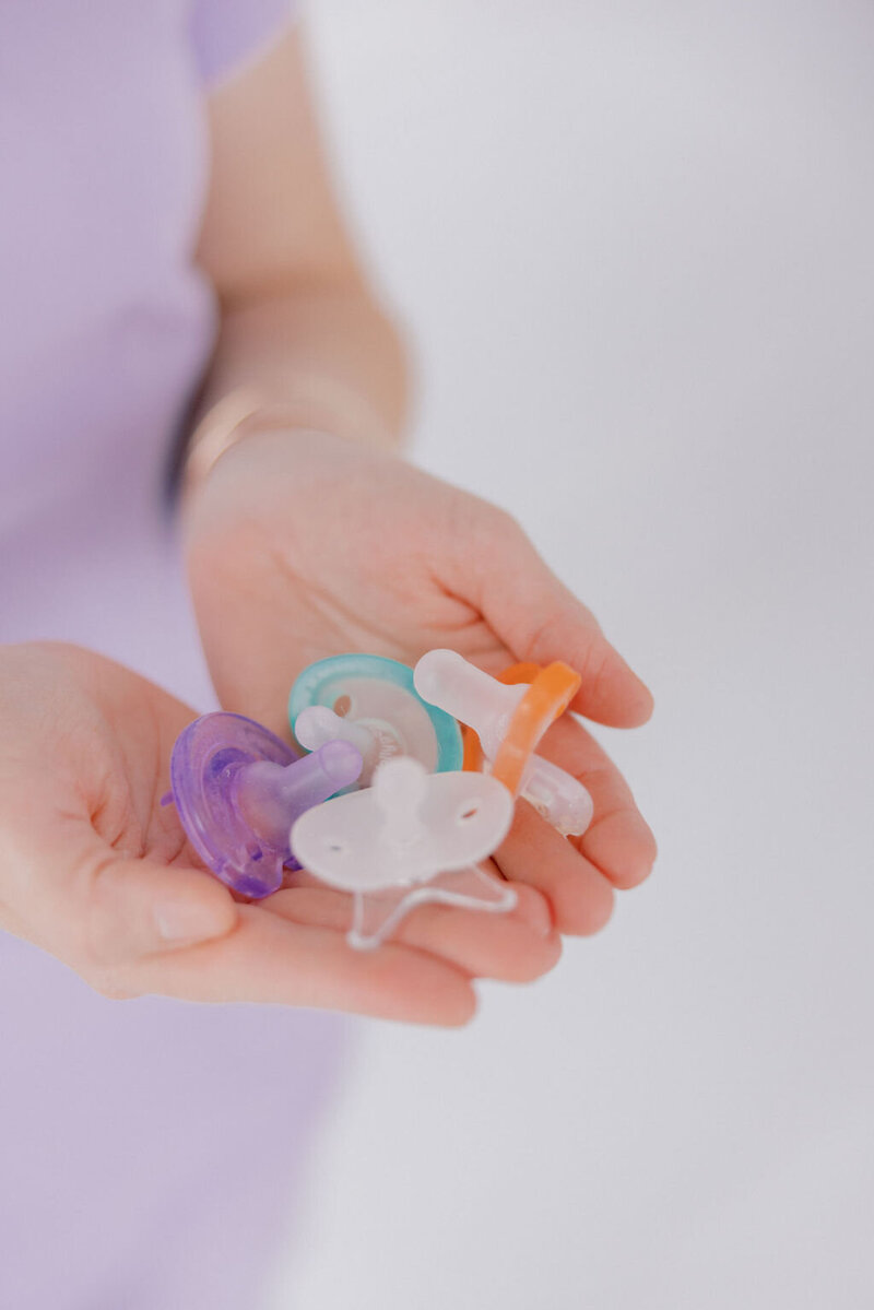 NICU therapist holding pacifiers