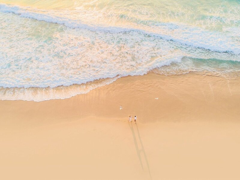 drone photo of a couple on a quiet beach in Maui taken during their beach engagement photoshoot