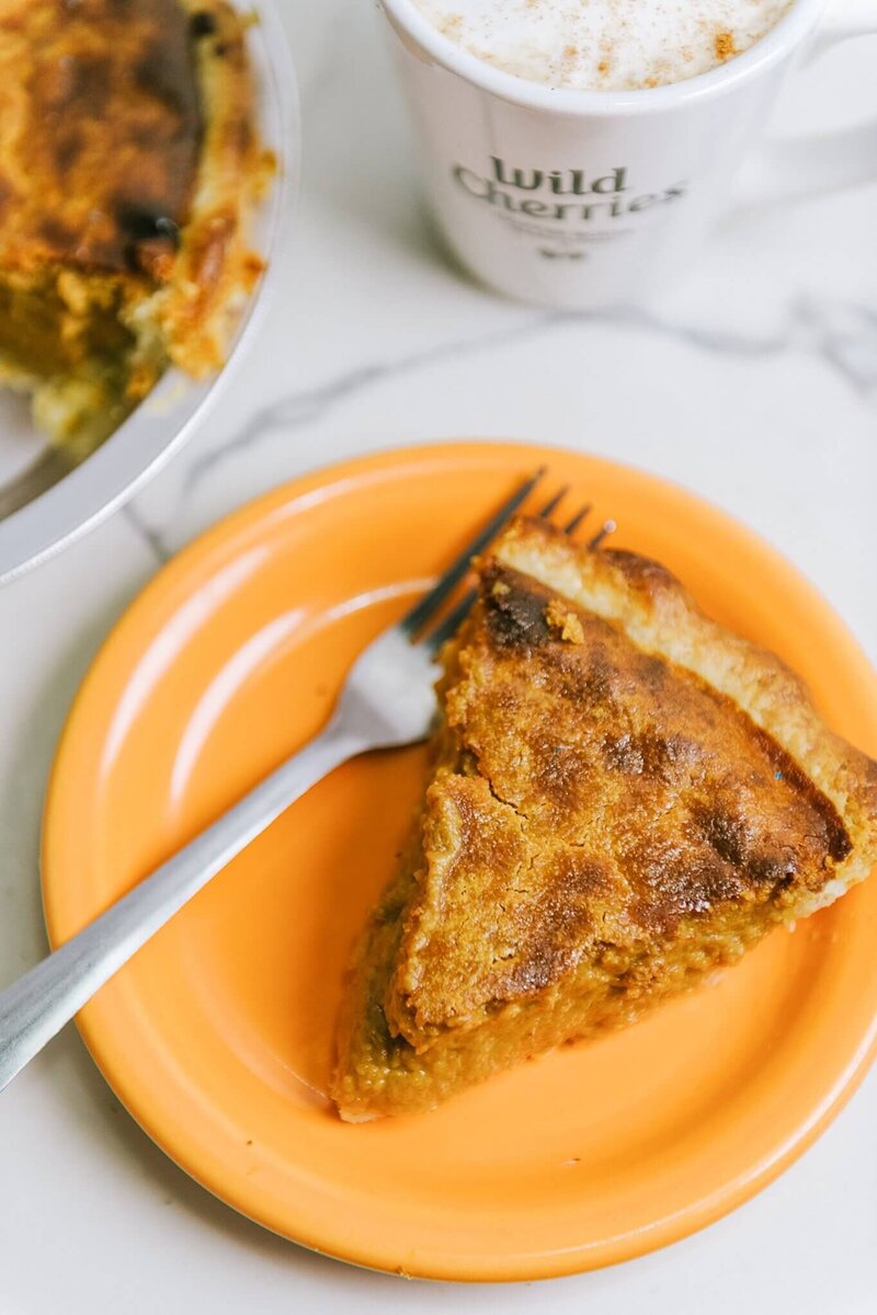 a slice of pumpkin pie displayed on an orange plate during a branding session at Wild Cherries coffee shop in Truckee
