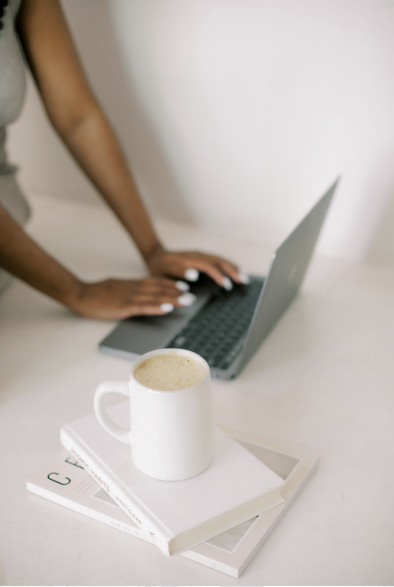Minimal stock photo of woman typing on laptop with coffee