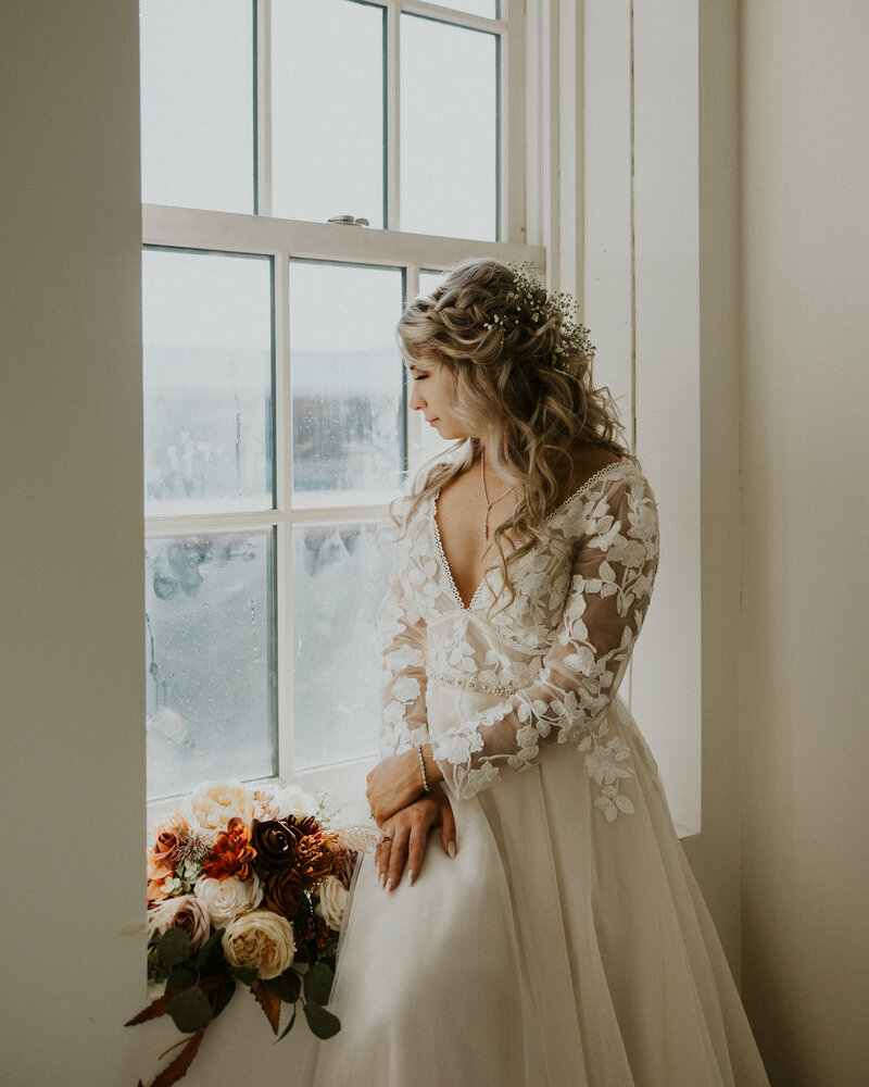 Bride sitting in window sill