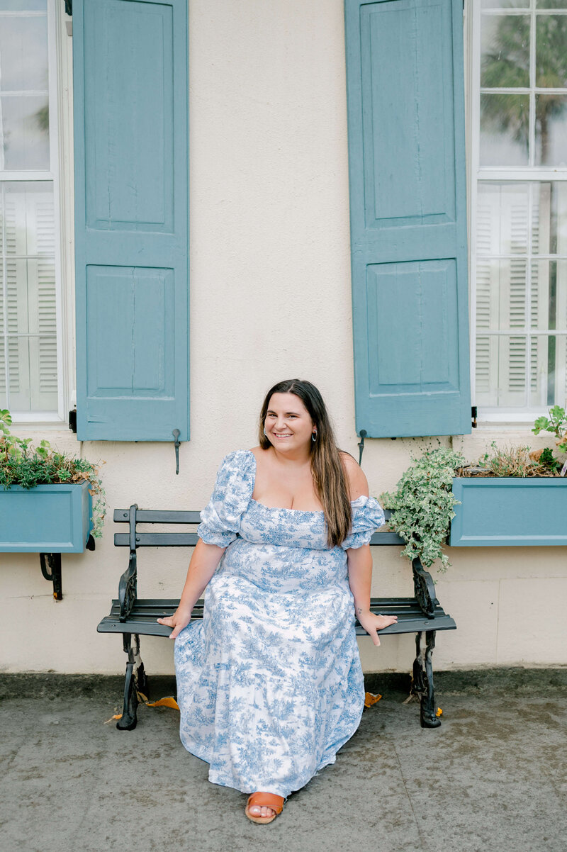 Photo of the Virginia wedding photographer, Rachael Mattio sitting on a bench in front of a Virginia private residence.