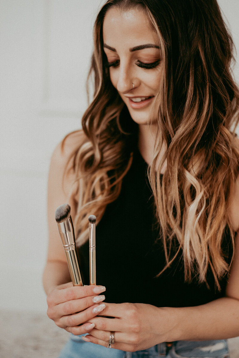 Makeup artist holding makeup brushes