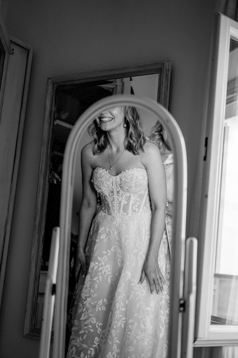 Bride portrait in front of a mirror with a lcae floral dress