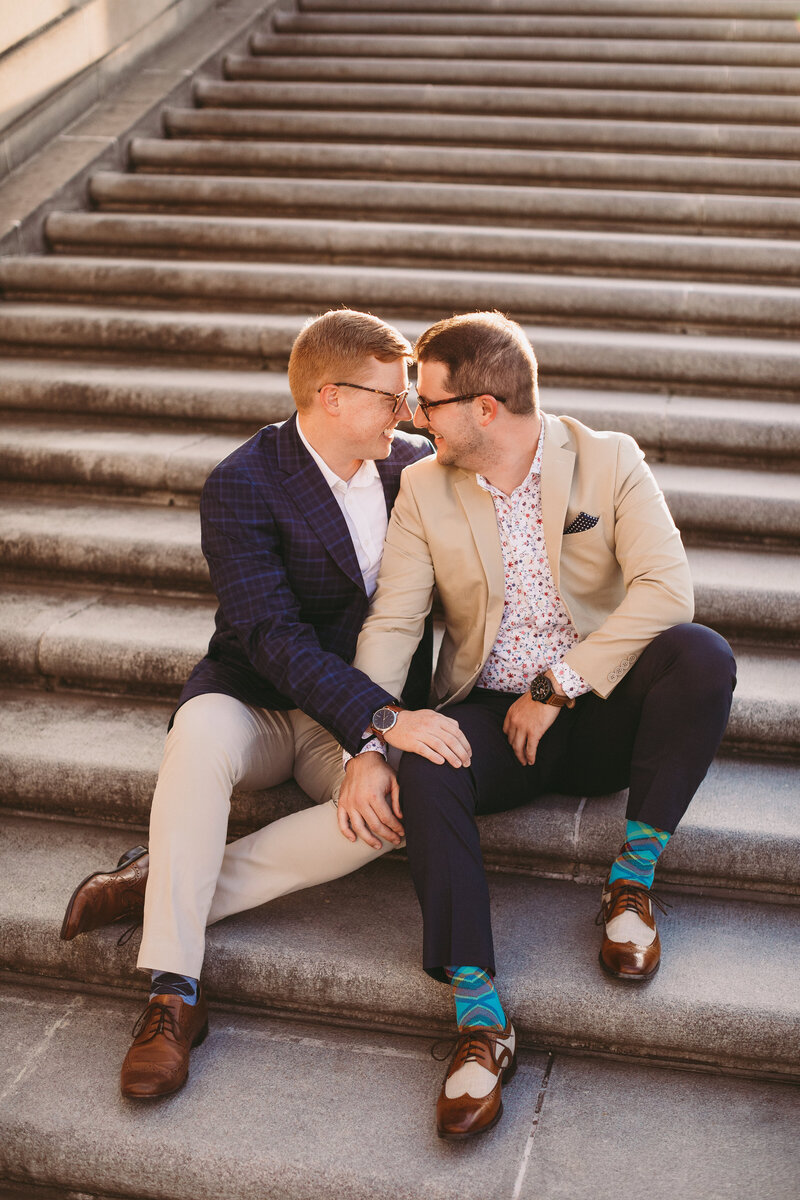 Couples photo of men sitting on stairs embracing each other