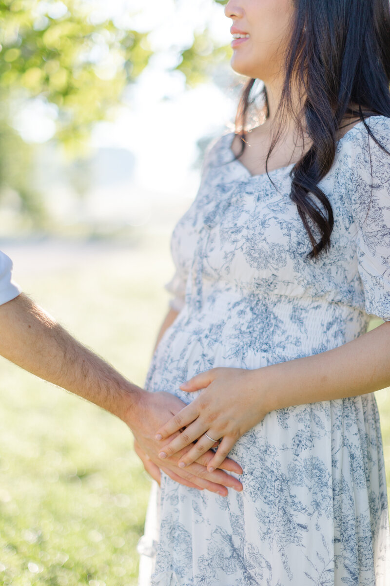 Father-to-be holds his wife's pregnant belly