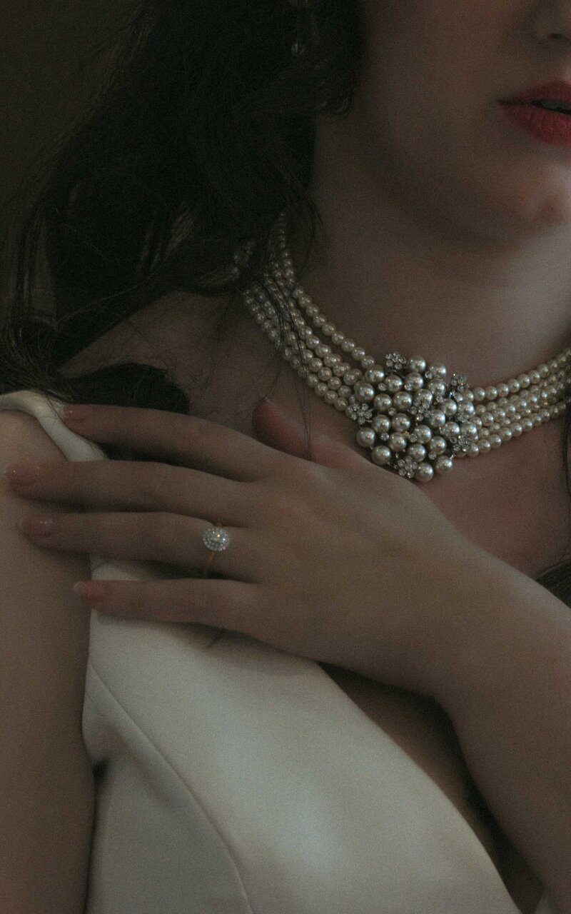 Bride adorned with a necklace and ring, radiating elegance and beauty, capturing a moment of bridal sophistication and timeless charm on her special day
