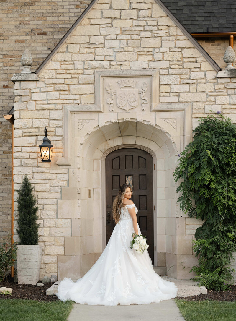 a bride by the front door at Venue3Two with a wedding photographer in Grand Rapids
