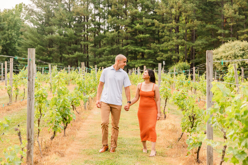 Couple walk along the vines at Eden Try Winery in Fredericksburg