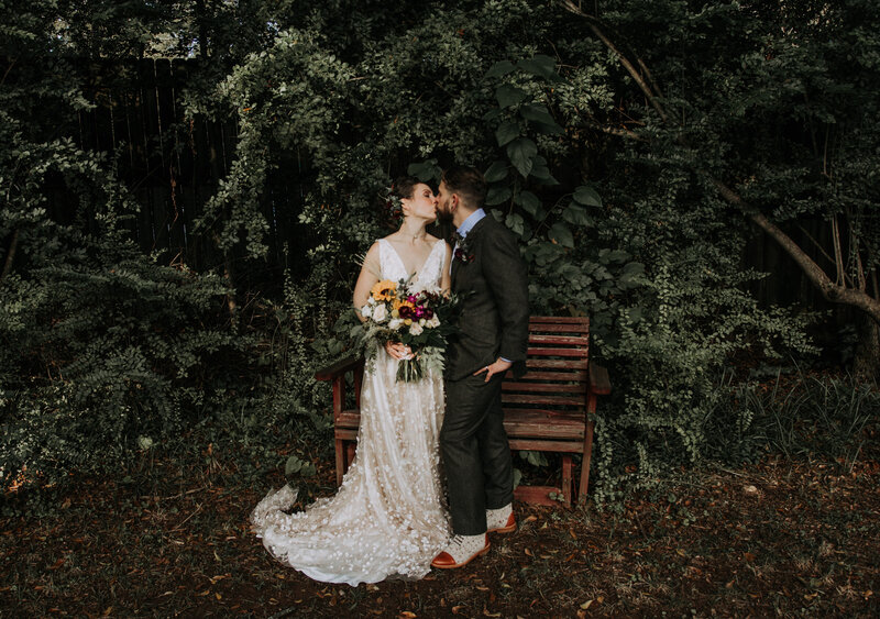 bride and groom kissing in a garden