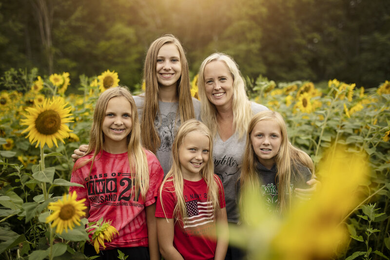 Mom with her four girls in a sunflower patch
