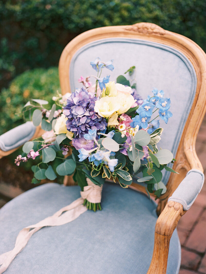 floral bouquet sitting on blue chair