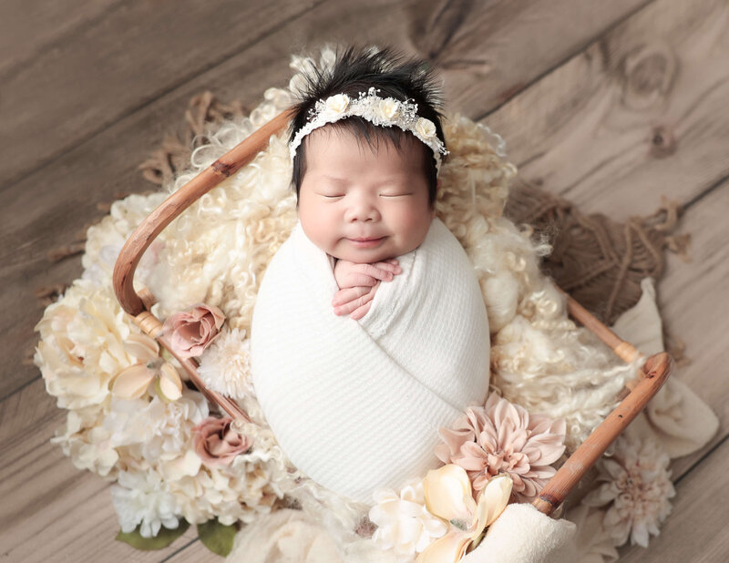 Smirking wrapped newborn girl at our Rochester, Ny studio.