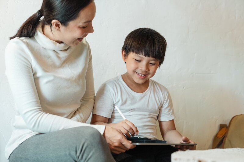 Asian mother and son doing homeschool studying activity