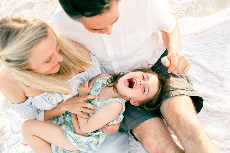 mom and dad with daughter on beach by new jersey family photographer