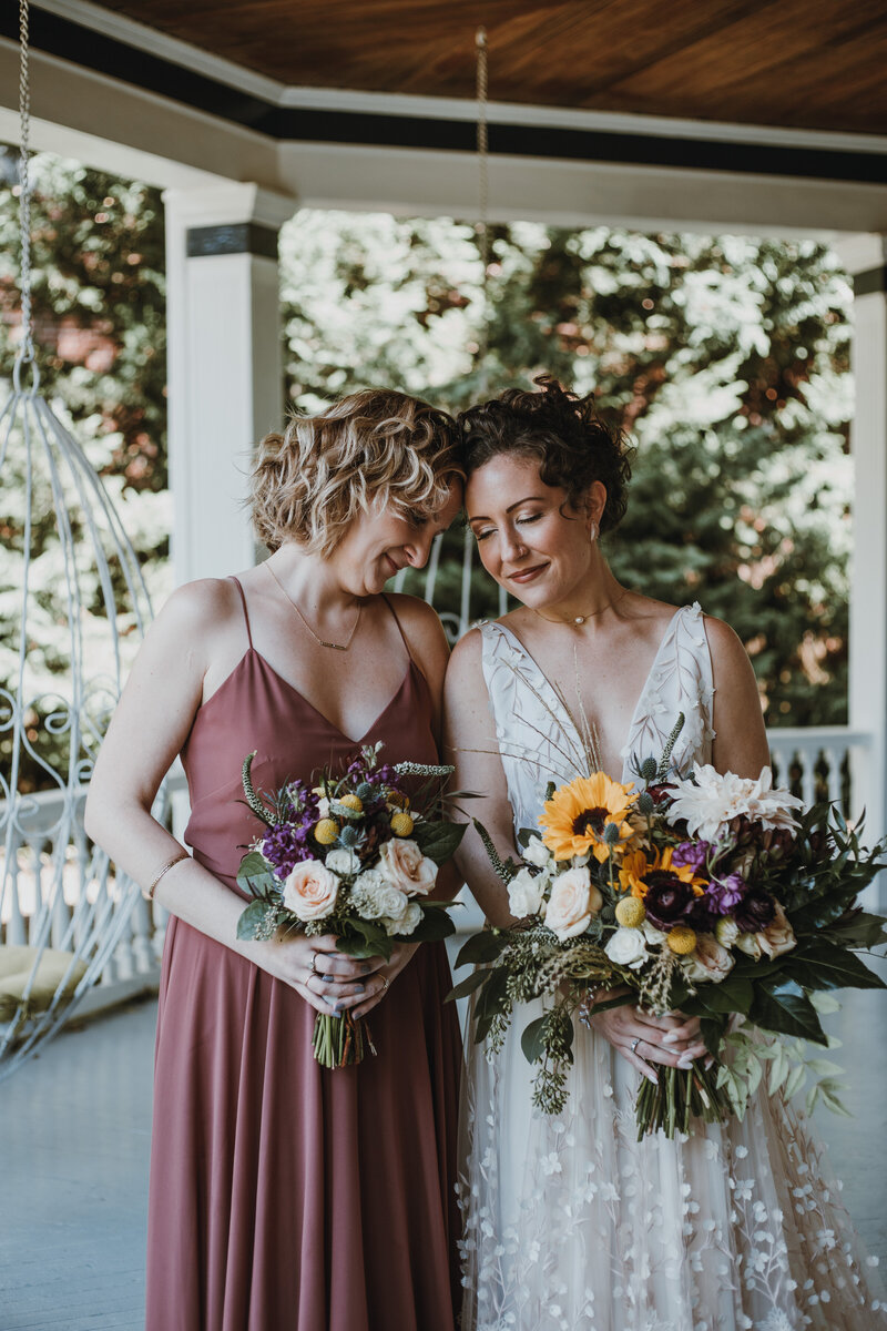 bride next to sister holding flowers